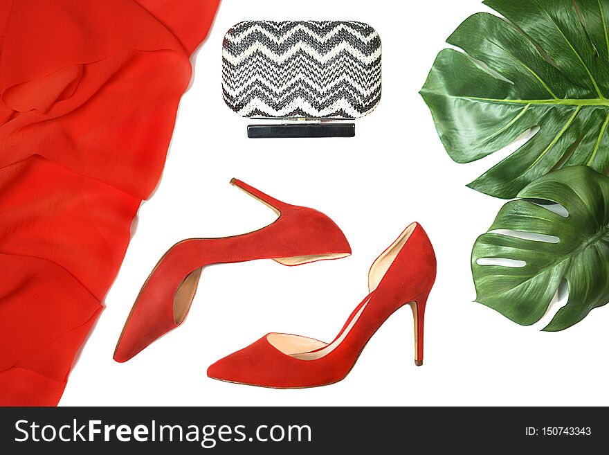 Top view party outfit red shoes accessories clutch tropical monstera leaves on white background, isolated.