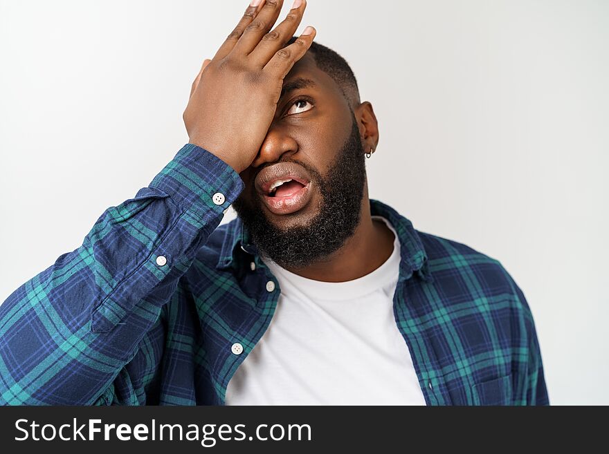 Studio shot of young handsome African man against white background.