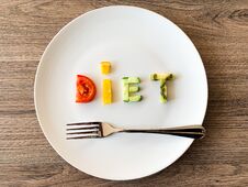 Word DIET Made Of Sliced Vegetables In Plate With Measuring On Wood Background Stock Image