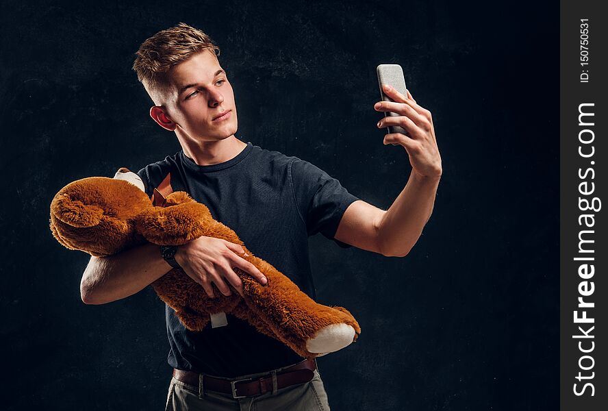 Young Attractive Man Is Making Selfie With Plush Toy