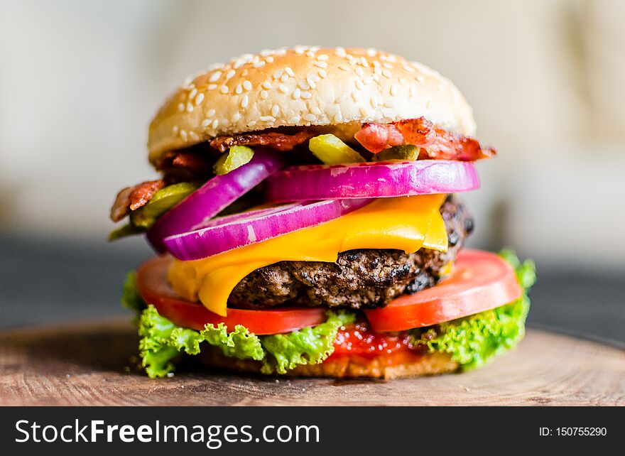 Burger On A Wooden Table Against Black Background