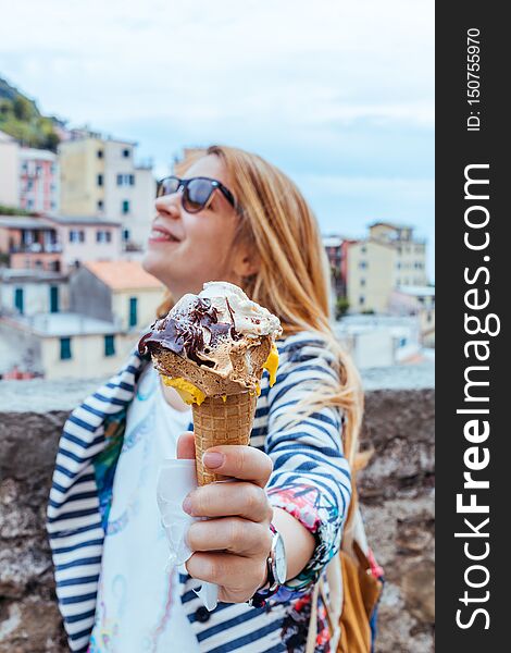 Young woman holding icecream in Manarola in the UNESCO World Heritage Site Cinque Terre, Liguria, Italy