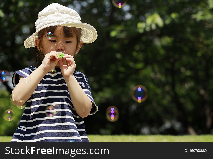 Japanese girl playing with bubble under the blue sky