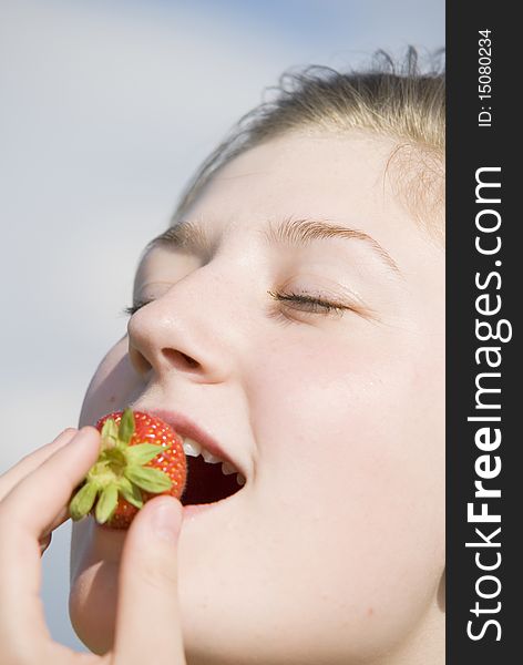 Young girl eating a stawberry, symbol of natur und healthy. Young girl eating a stawberry, symbol of natur und healthy