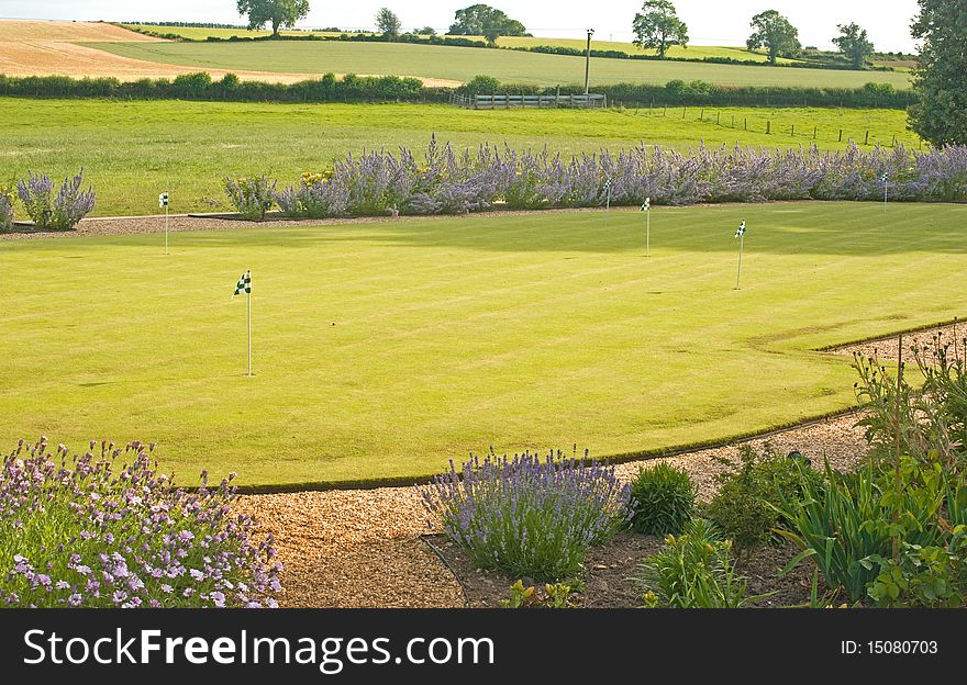 An image of a lawn in the garden of  a house turned into a putting green for golf practice. An image of a lawn in the garden of  a house turned into a putting green for golf practice.