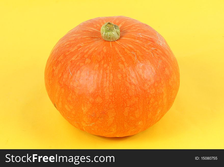 Orange pumpkin on yellow background