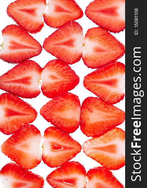 Sliced strawberries put in rows on white background