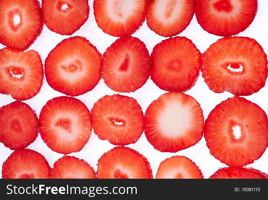 Sliced strawberries put in rows on white background