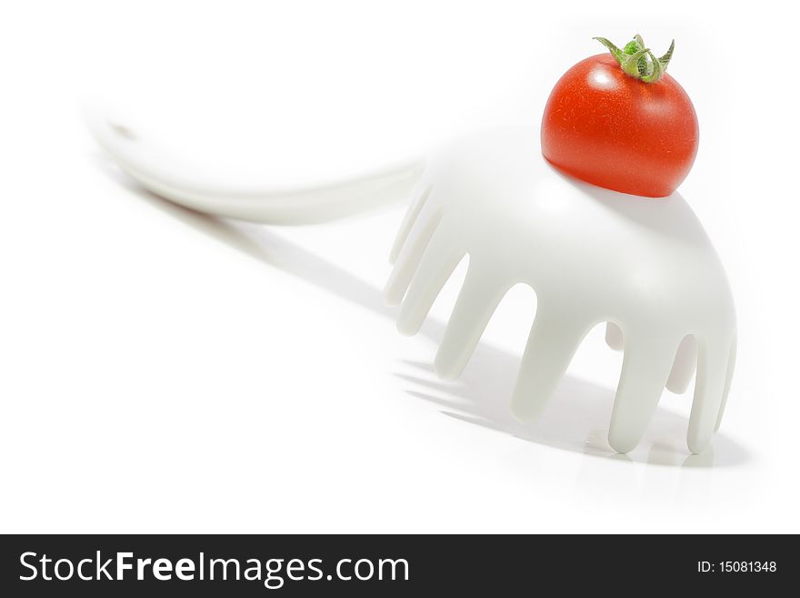 Ripe cherry tomato on a pasta ladle/fork. Isolated on white background.