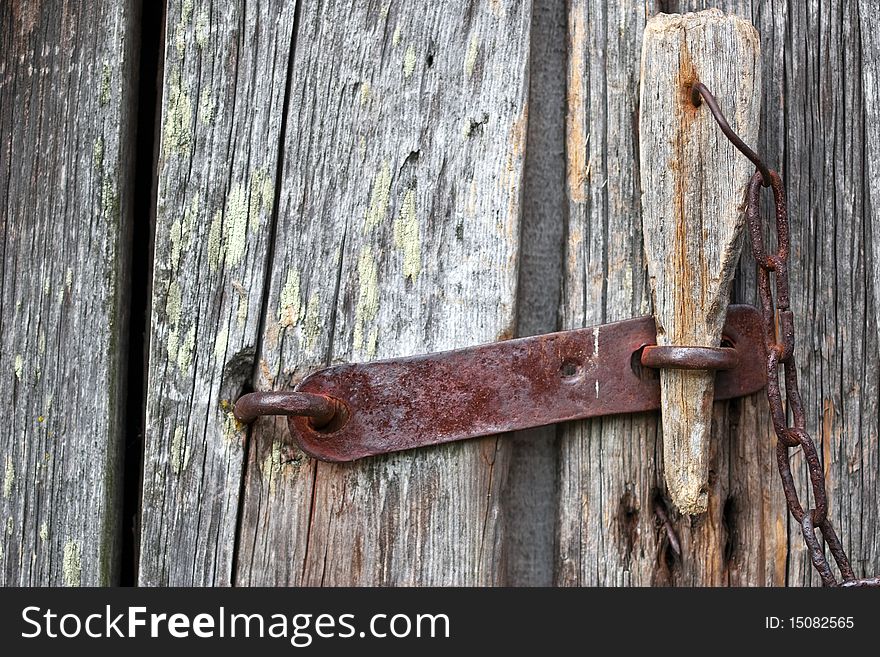 Fragment of the old wooden door with a padlock