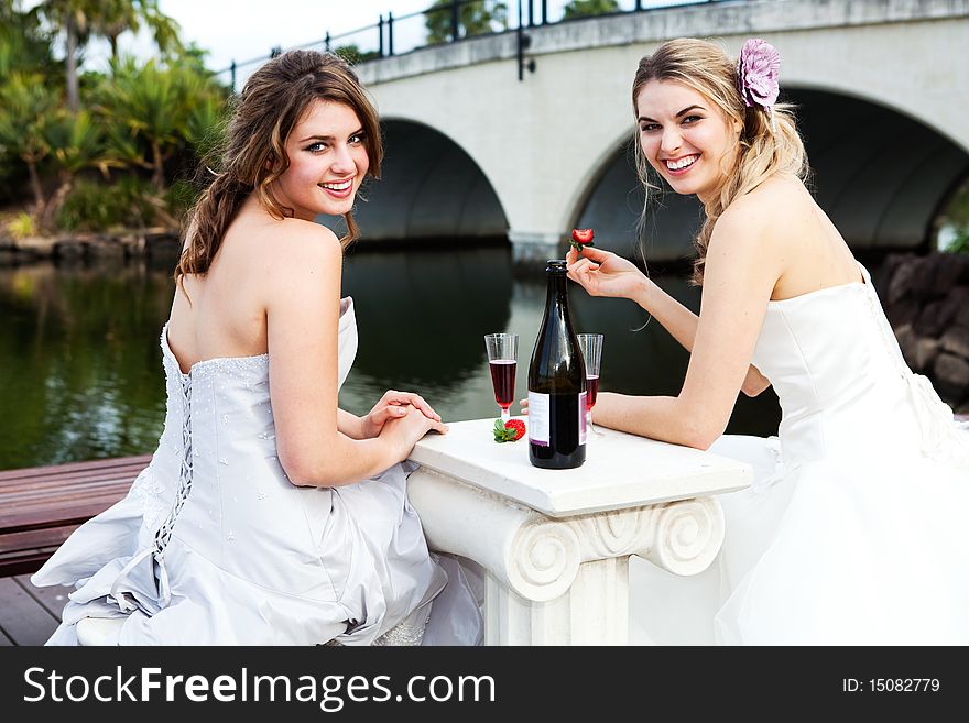 Young Women In Gowns Sharing A Drink