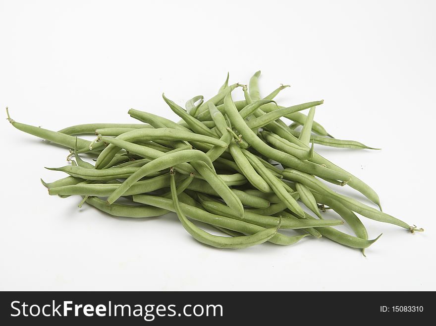Many raw green beans isolated over white