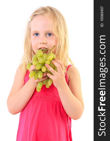 Little baby girl eats the big grapes, isolated on white