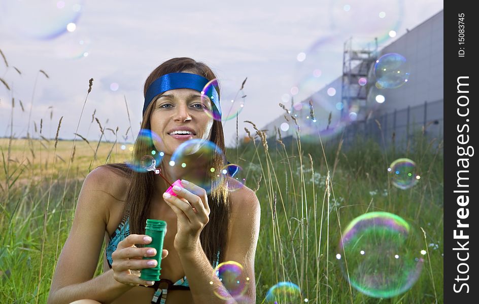 Beauty young woman blowing soap bubbles in summer day. Beauty young woman blowing soap bubbles in summer day