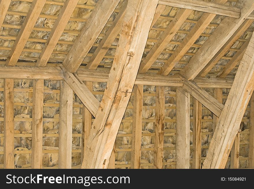 An image in horizontal format of the roof of a church from inside the building showing ancient timber beams and stone slates. An image in horizontal format of the roof of a church from inside the building showing ancient timber beams and stone slates.