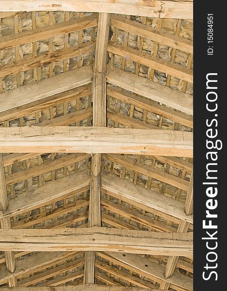 An image in vertical format of the roof of a 13th century church from inside the building showing ancient timber beams and stone slates. An image in vertical format of the roof of a 13th century church from inside the building showing ancient timber beams and stone slates.