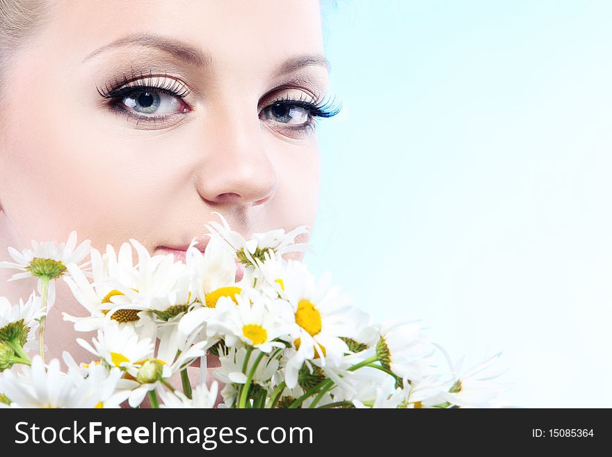 Close-up portrait of a fresh and beautiful woman with camomile.