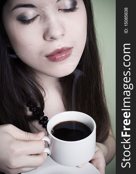 Part of the person of the young brunette holding a cup of coffee. Part of the person of the young brunette holding a cup of coffee.