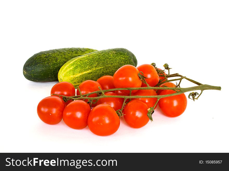 Branch of tomatoes cherry and cucumbres  in isolated over white. Branch of tomatoes cherry and cucumbres  in isolated over white