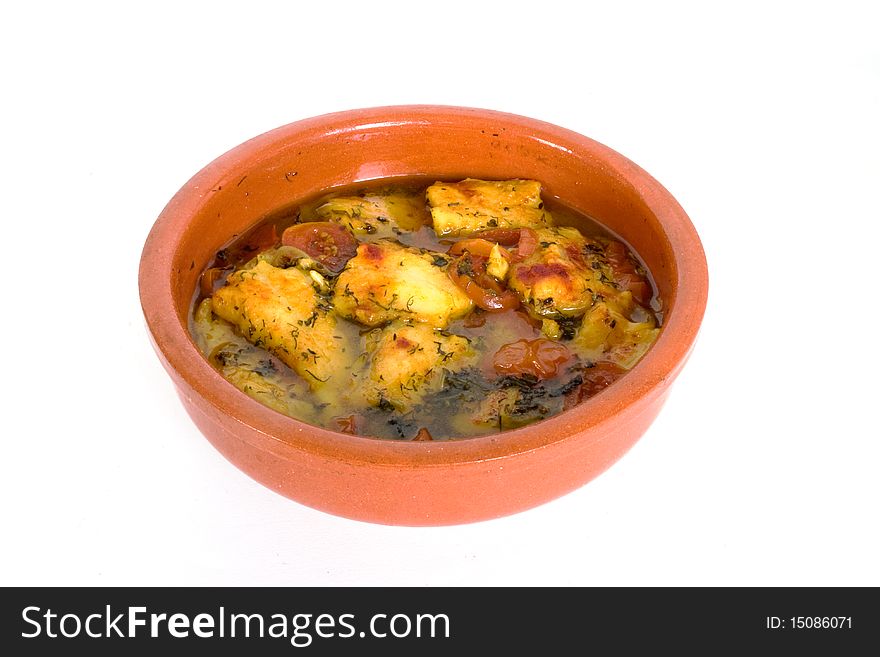 Stewed fish with vegetables in ceramic dish in isolated over white