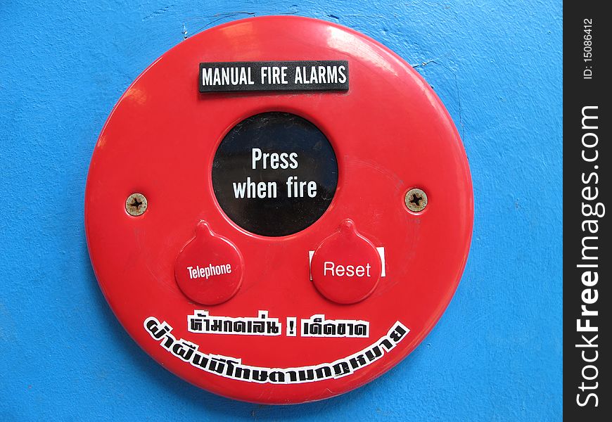 Red Fire Alarm Bell Sign  On The Blue Wall