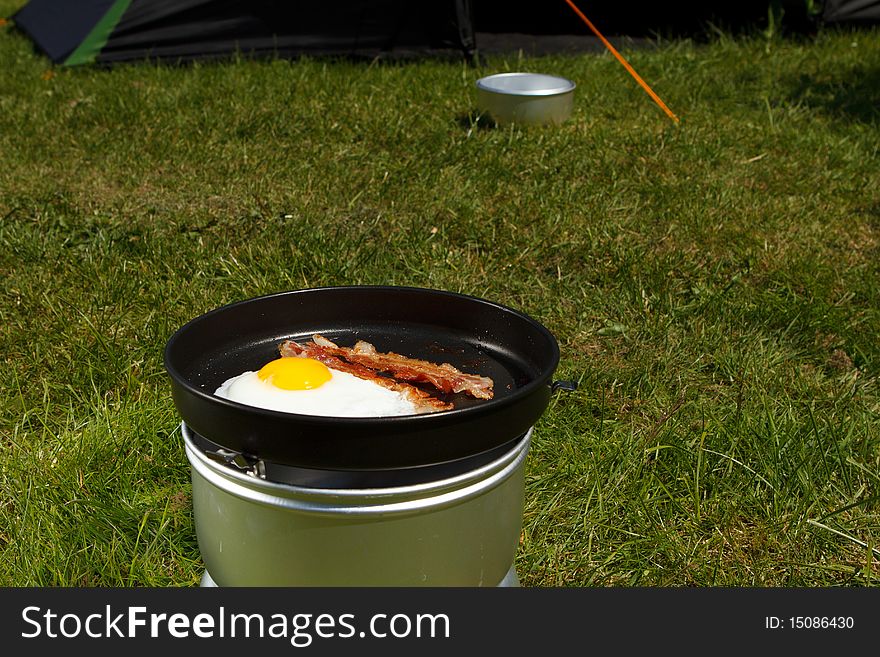 Camping breakfast. Eggs and bacon by the tent