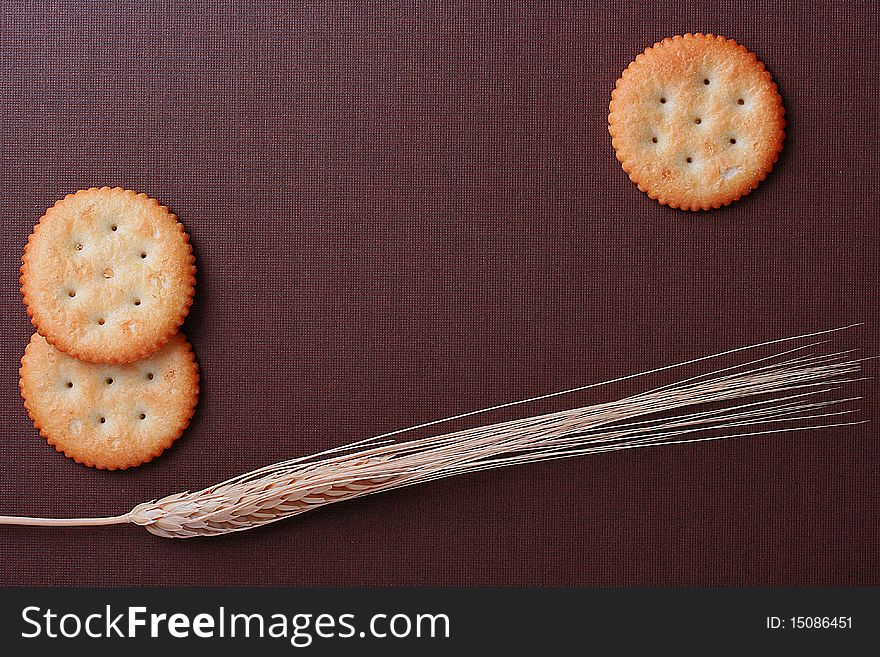 Round cookies on a brown background with a wheaten ear. Round cookies on a brown background with a wheaten ear.