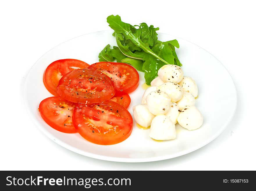 Mozzarella and tomato salad with olive oil and rocket. Mozzarella and tomato salad with olive oil and rocket