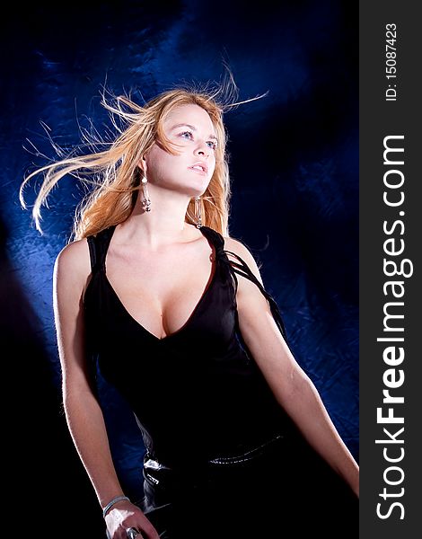 Beautiful blondie woman with spreading hair dancing, black background