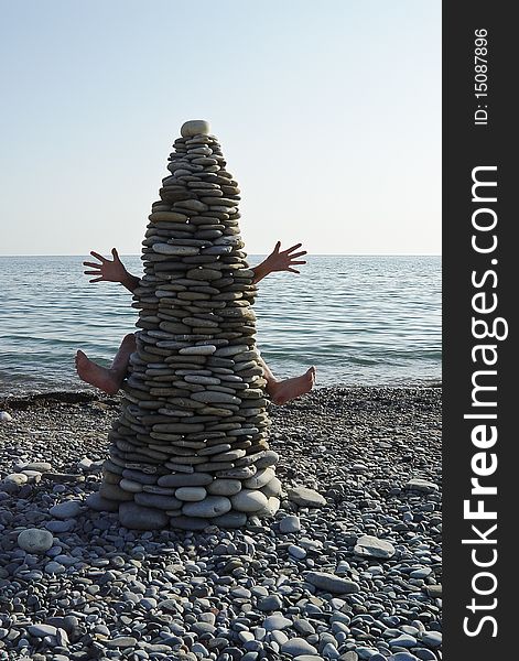 Stone tower with hands and legs on the beach