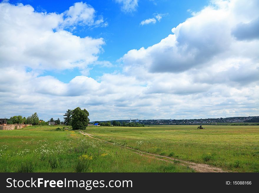 Large field and a village with church on the horizon. Large field and a village with church on the horizon