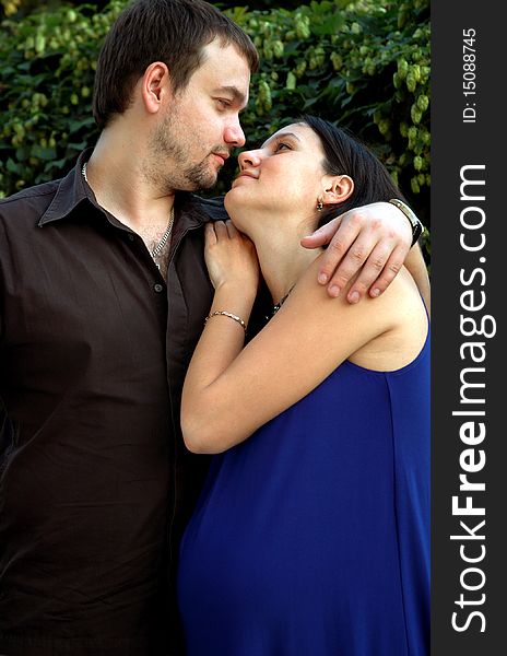 Pregnant couple on a background of green. Pregnant couple on a background of green
