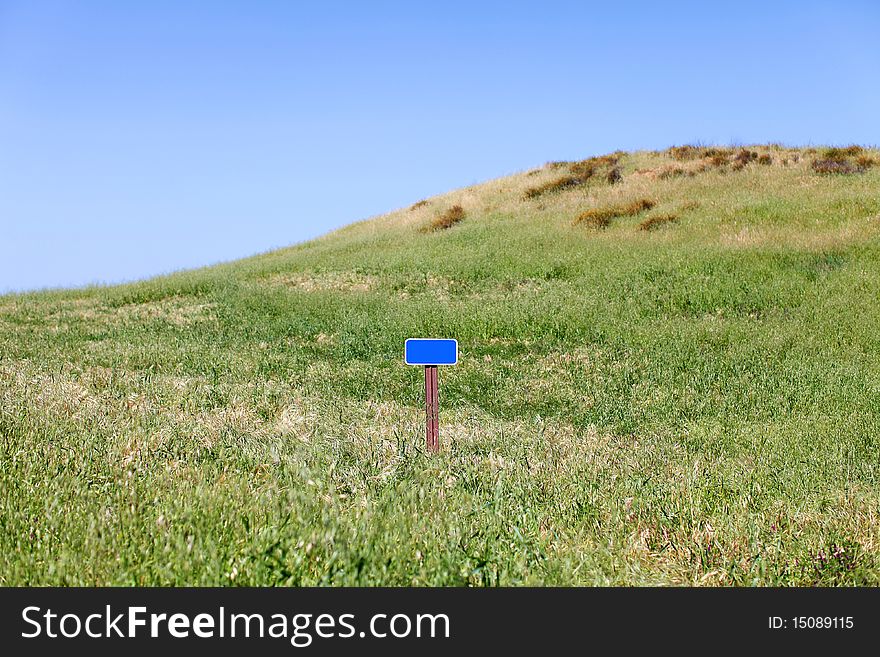 Blank sign on a grassy hill