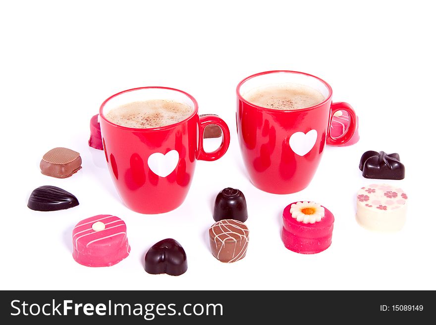 Two lovely cups with coffee and chocolate candy isolated over white