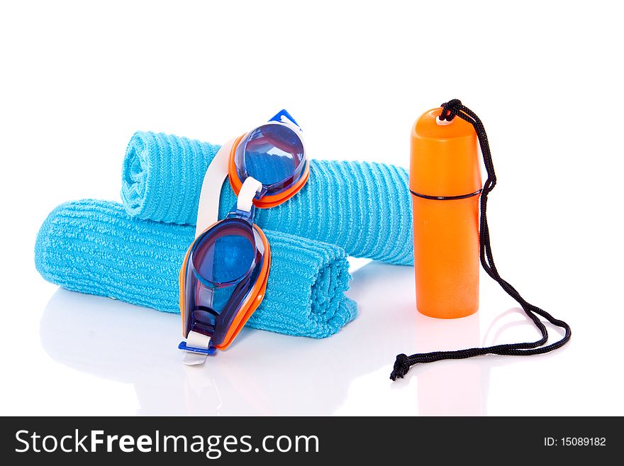 A money box and a goggle on blue towels isolated over white. A money box and a goggle on blue towels isolated over white