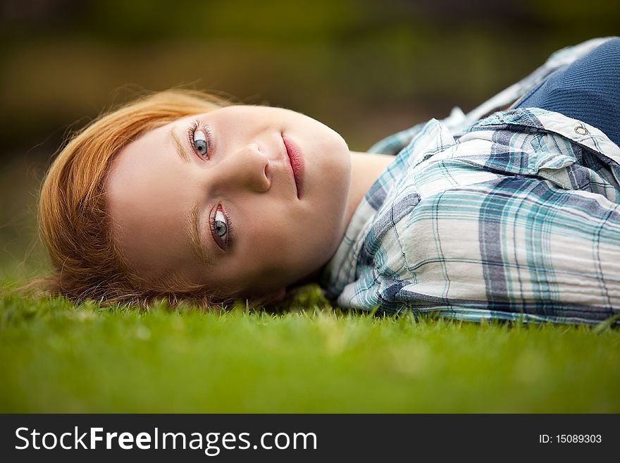 Young woman relaxing outside in the grass