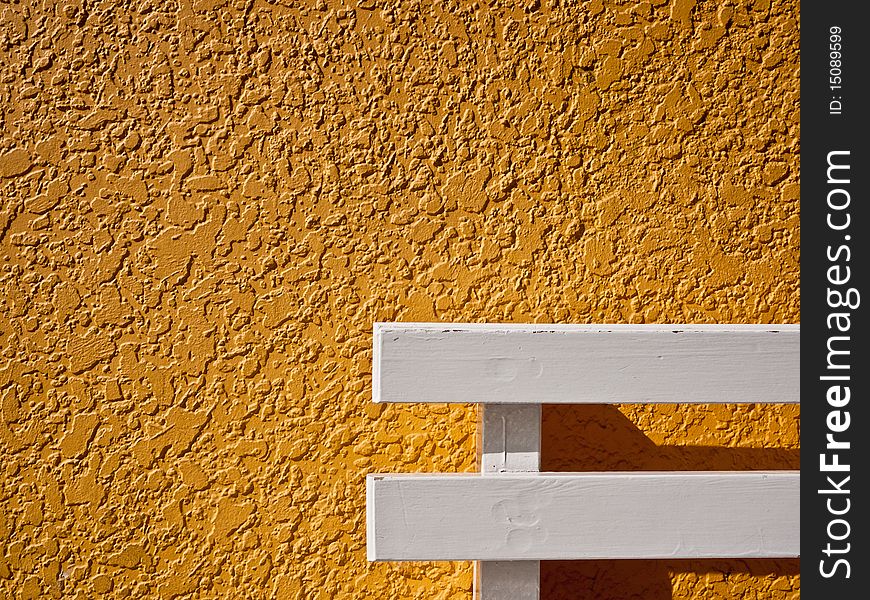Yellow stucco abstract with white bench. Yellow stucco abstract with white bench