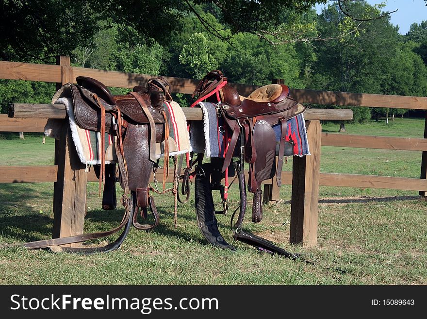Saddles on a rail fence