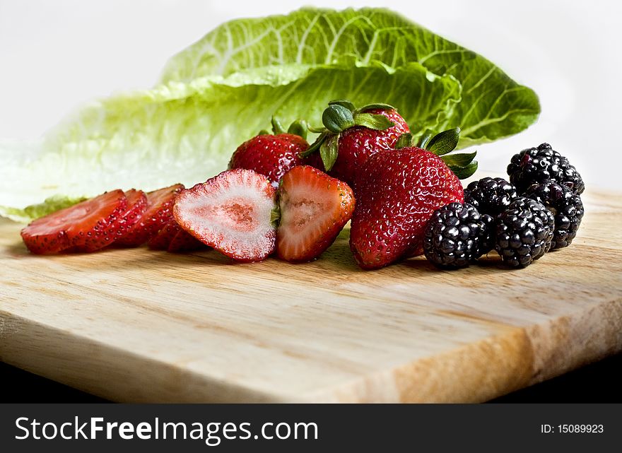 Fresh berries and lettuce on a cutboard. Fresh berries and lettuce on a cutboard