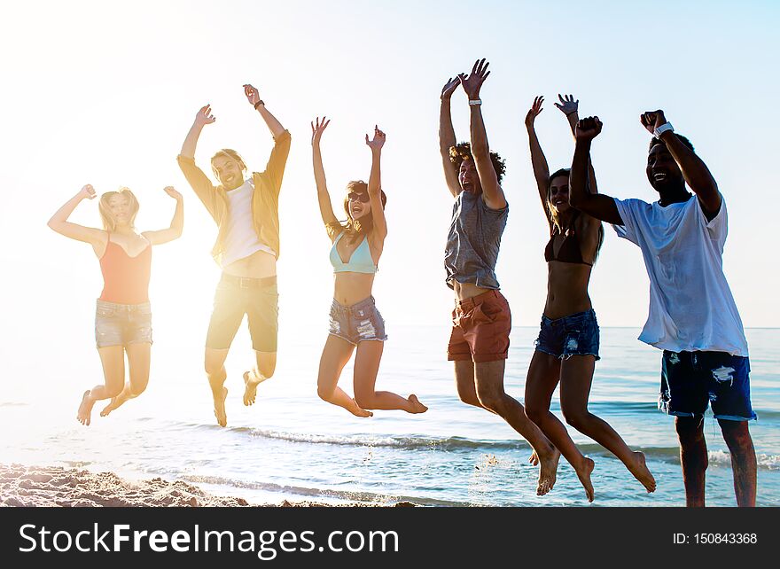 Happy Smiling Friends Jumping At The Beach