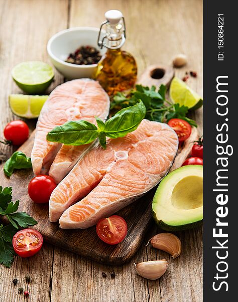 Raw salmon steaks and ingredients on a old wooden table