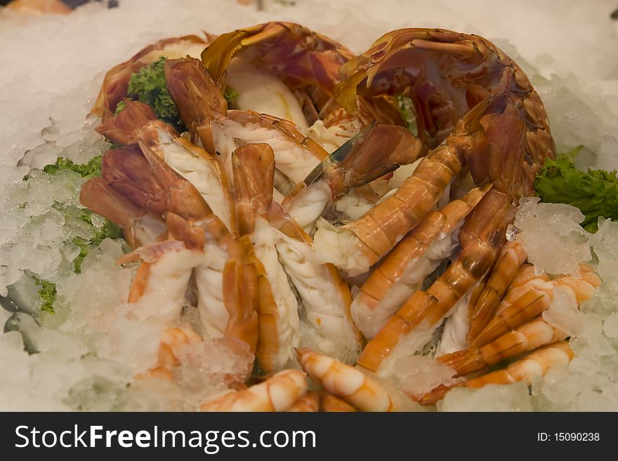 Lot of fresh delicious shrimps with decorated green salad in a fish restaurant. Lot of fresh delicious shrimps with decorated green salad in a fish restaurant.