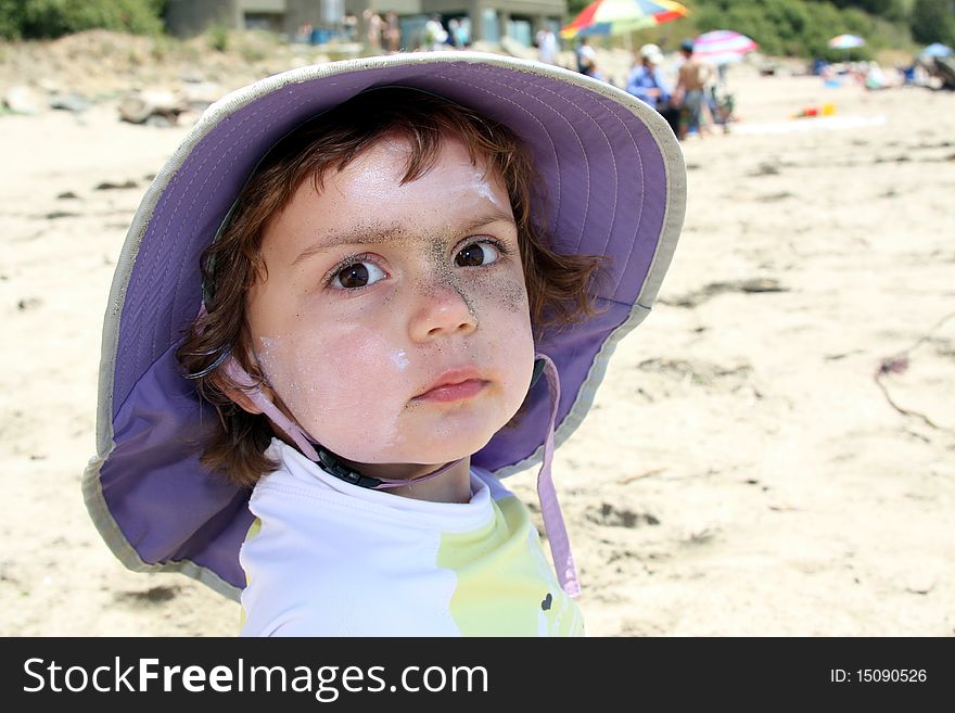 Child with sunscreen and sand on face. Child with sunscreen and sand on face