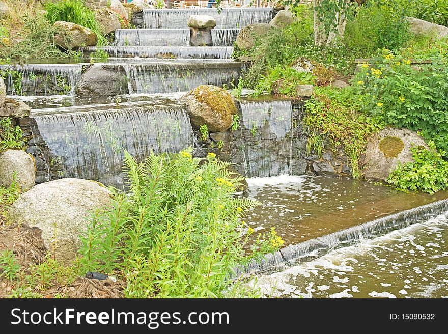 An image of a  waterfall designed and constructed to blend into an urban environment. An image of a  waterfall designed and constructed to blend into an urban environment.