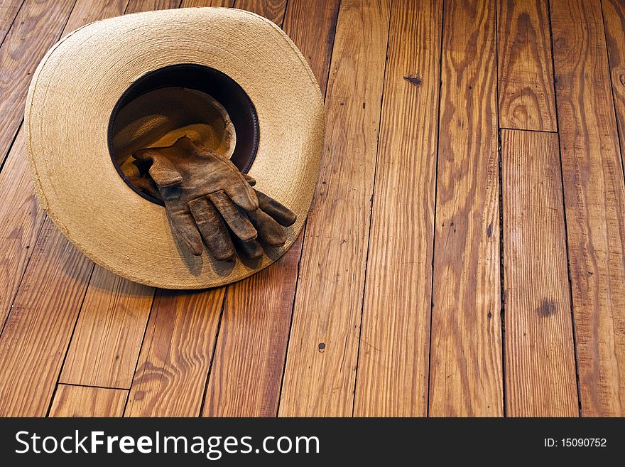 Cowboy Hat and Work Gloves on a wooden table. Cowboy Hat and Work Gloves on a wooden table