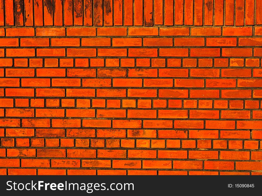 New orange brick wall with vertical and horizontal pattern.