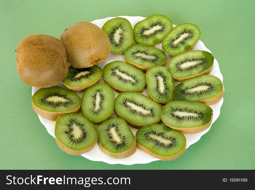 Slices of ripe fresh  kiwi on plate over green