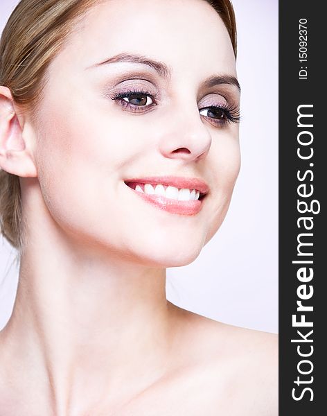 Closeup, studio shot of a young beautiful, blonde woman with smile and hair pull back. Closeup, studio shot of a young beautiful, blonde woman with smile and hair pull back