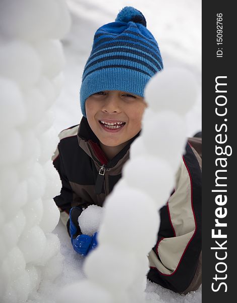 Young Boy Behind Snowball Wall