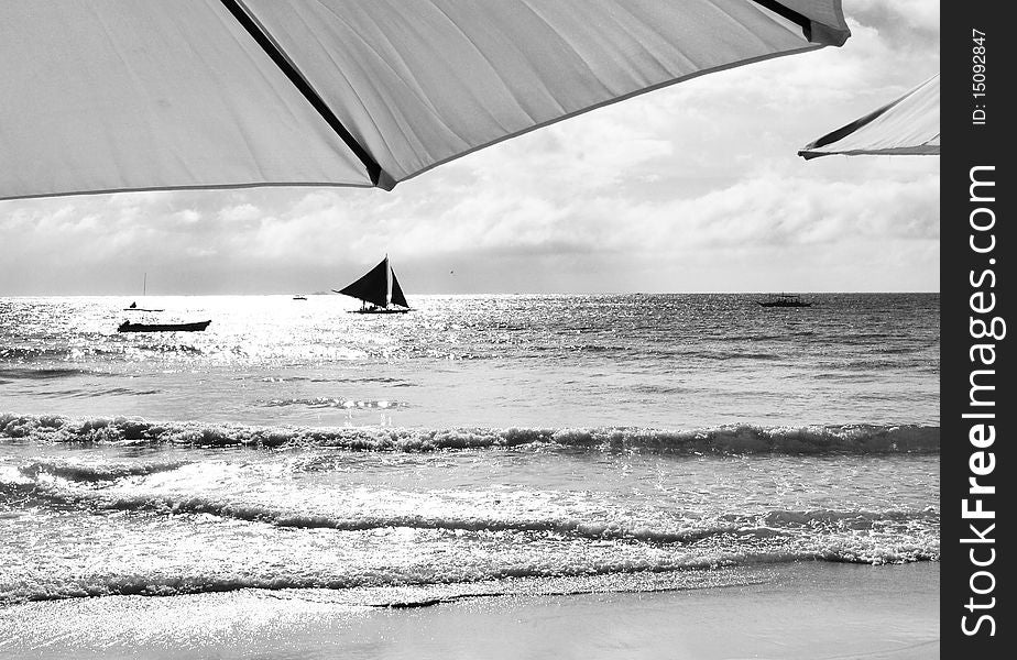 A black and white photo, a good view of a sailboat under an umbrella at a boracay beach, AKLAN, Philippines.